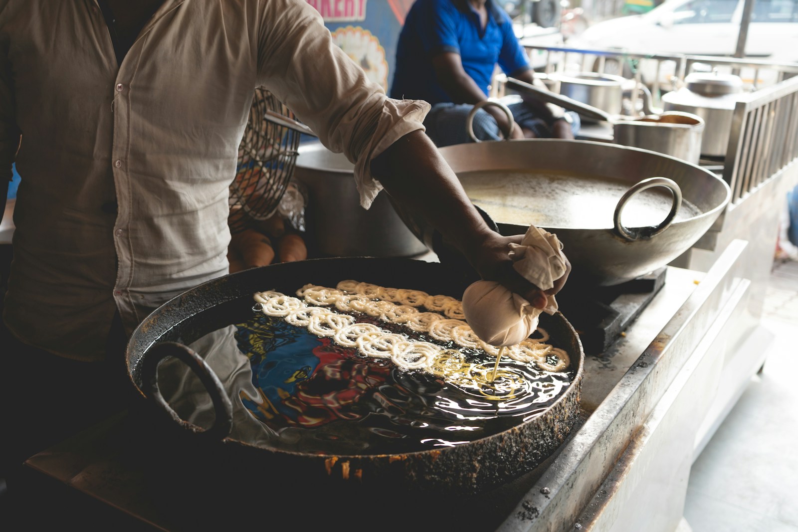 A man standing over a pan of food on top of a stove